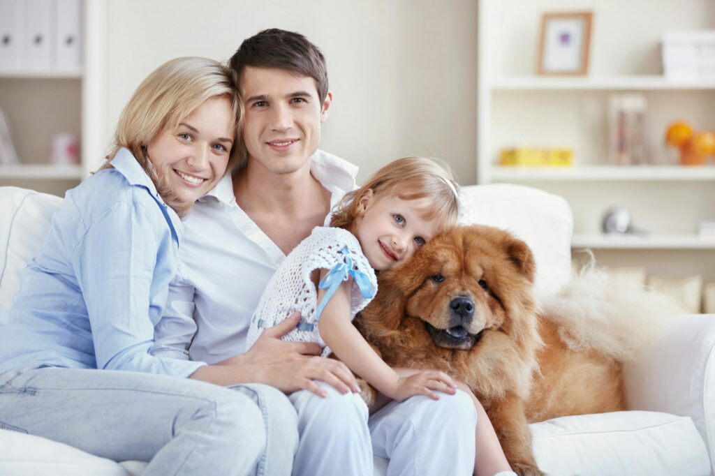 Happy family with a dog at home after flea and tick solutions.
